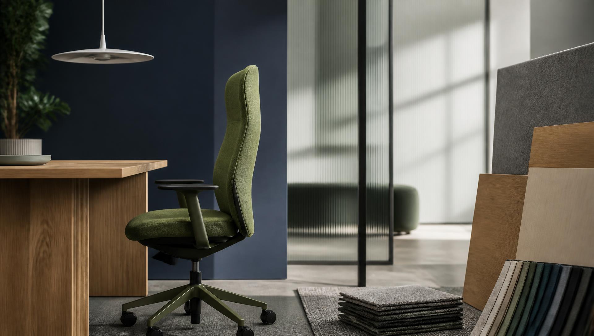 Contract office chair, oak desk, pendant light, glass partition, acoustic panel, flooring and textile samples in a showroom setting